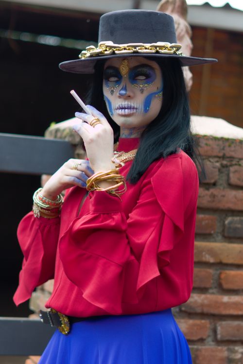 Free Elegant Catrina portrait with face paint and vivid clothing for Day of the Dead celebration. Stock Photo