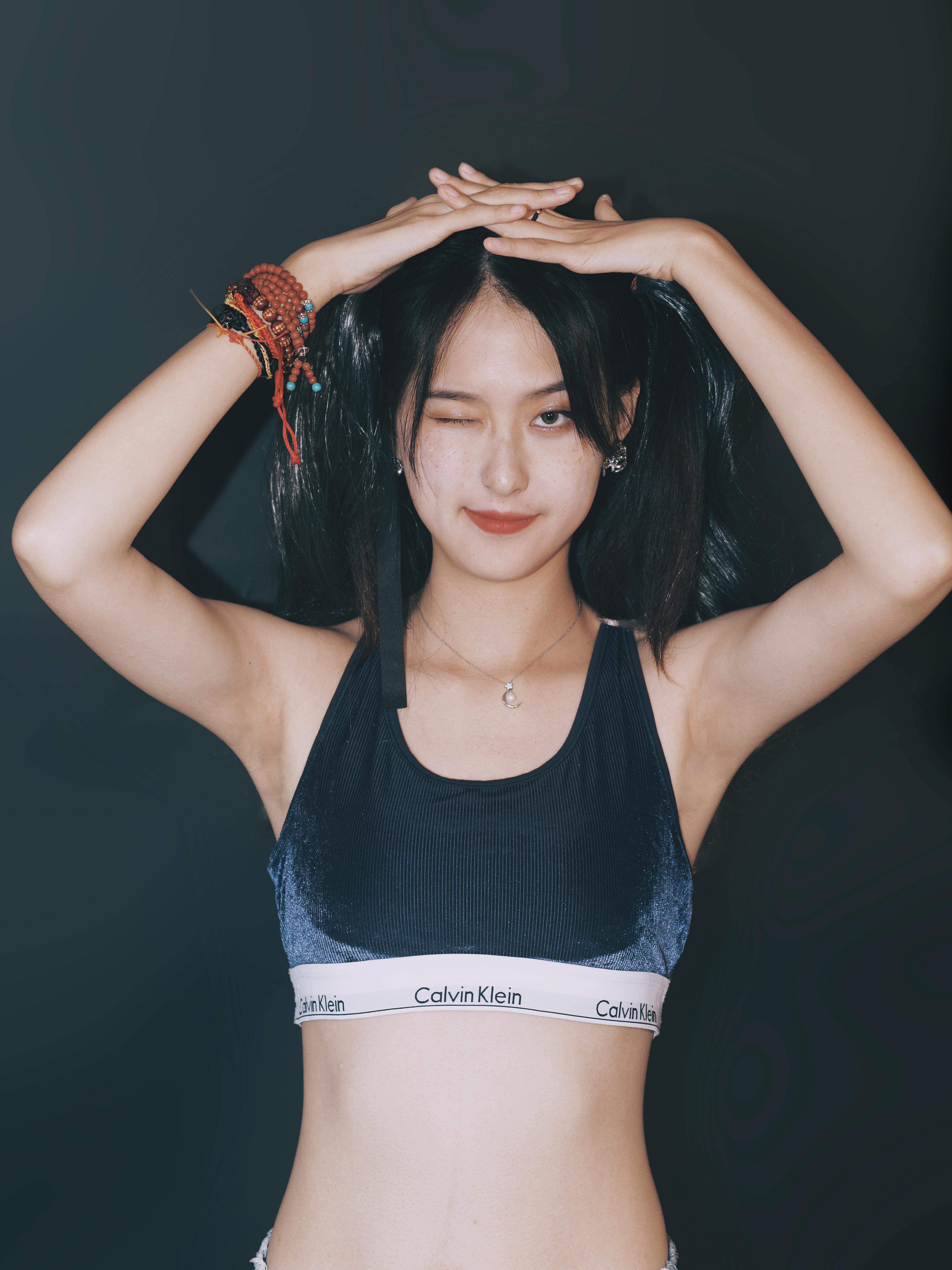Free Young Asian woman with playful pose and confident expression wearing a black sports top. Stock Photo