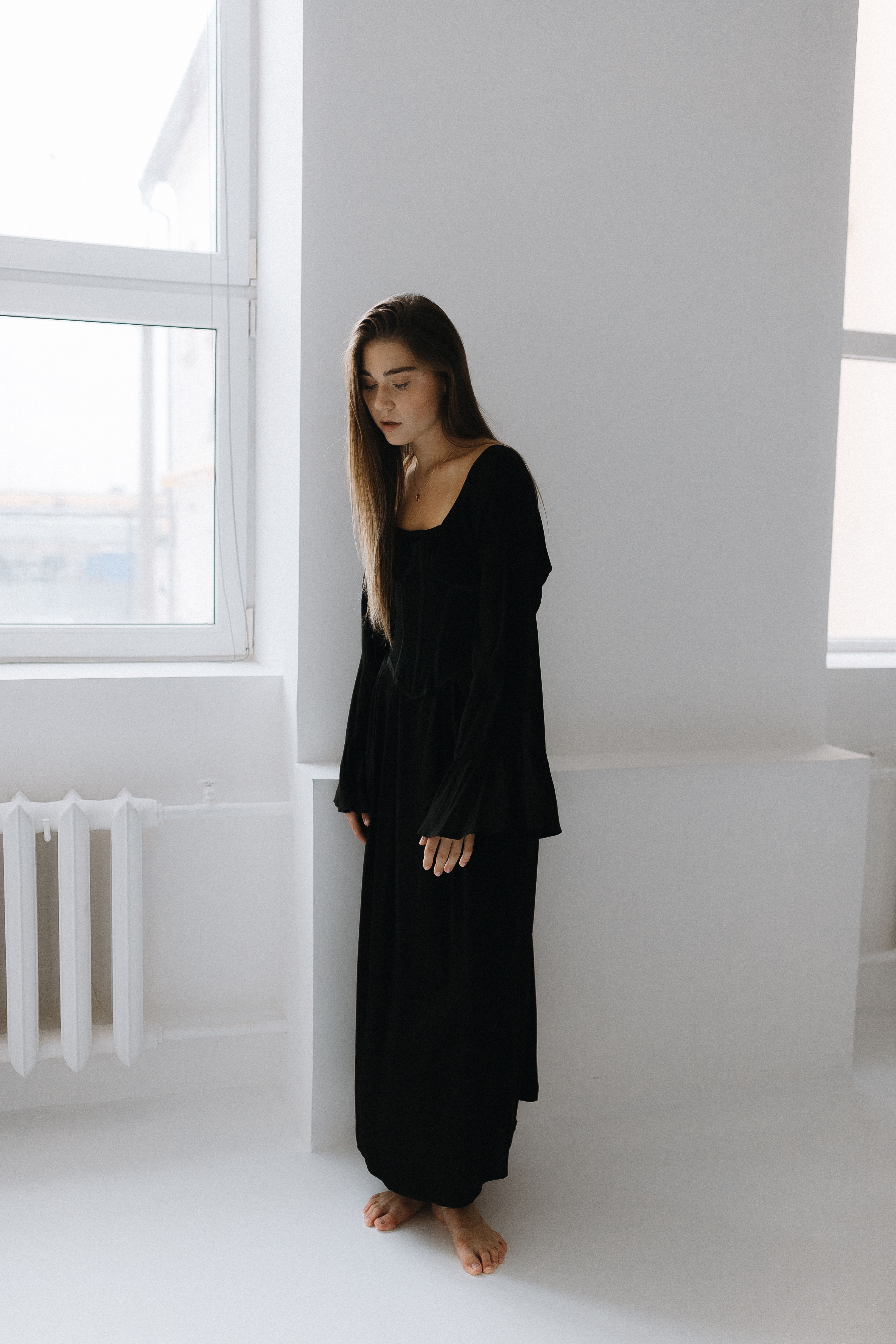 Beautiful Young Woman in a Black Long Dress Looking Down · Free Stock Photo