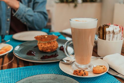 Acogedor brunch en cafetería con café latte y pasteles