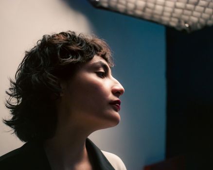 Profile portrait of a woman with soft side lighting, creating a dramatic effect.