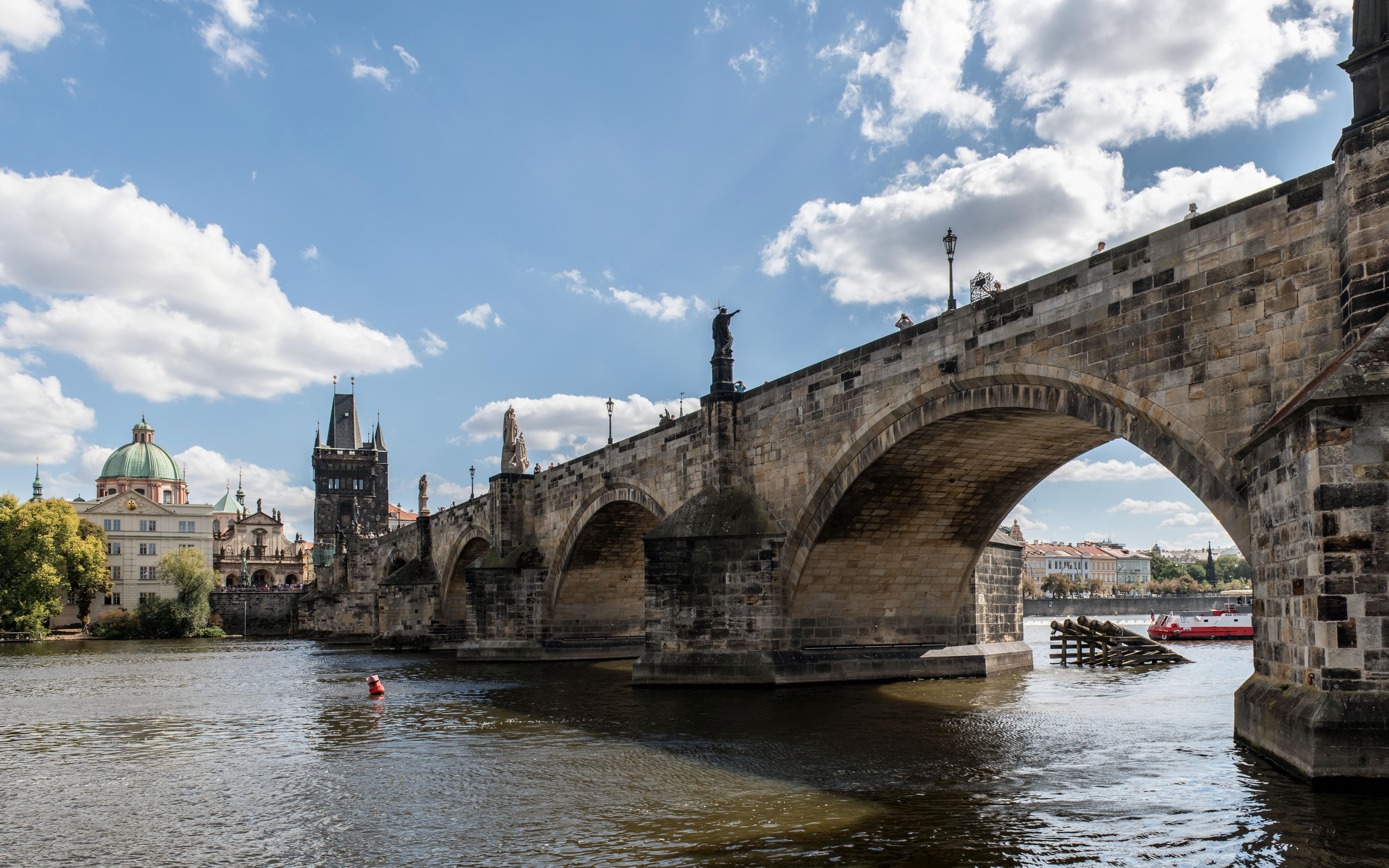 A scenic view of the historic Charles Bridge crossing the Vltava River in Prague.
