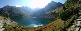 壮丽的山峰环绕着宁静的山湖，阳光洒满全景