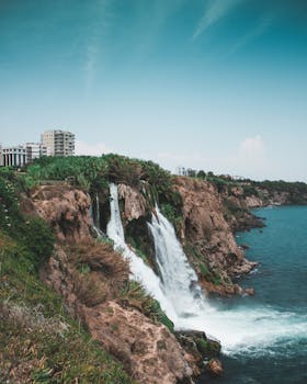 悬崖上的瀑布流入大海，天空晴朗，景色壮丽而宁静