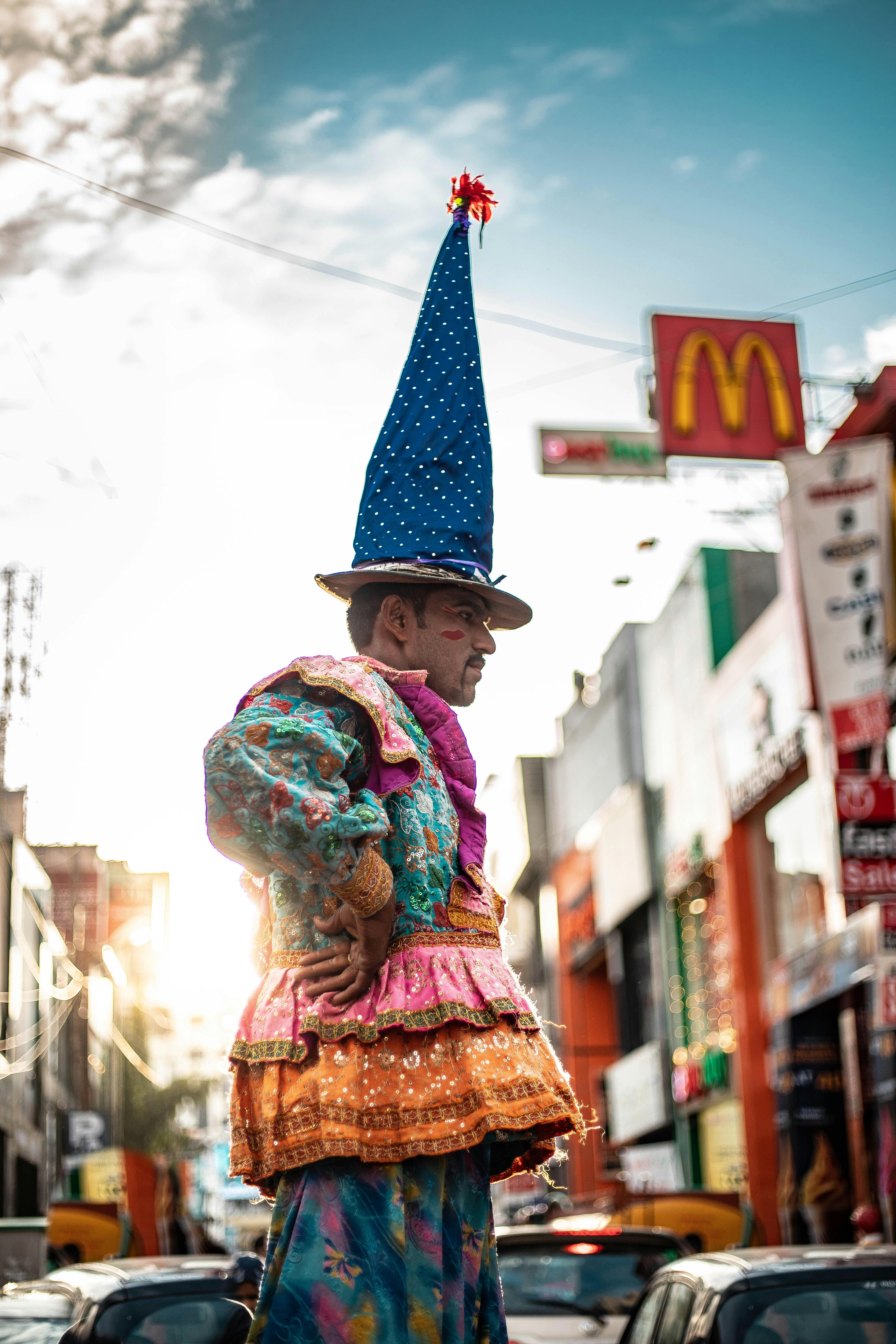 白天，小丑穿着充满活力的服装，出现在熙熙攘攘的城市背景中