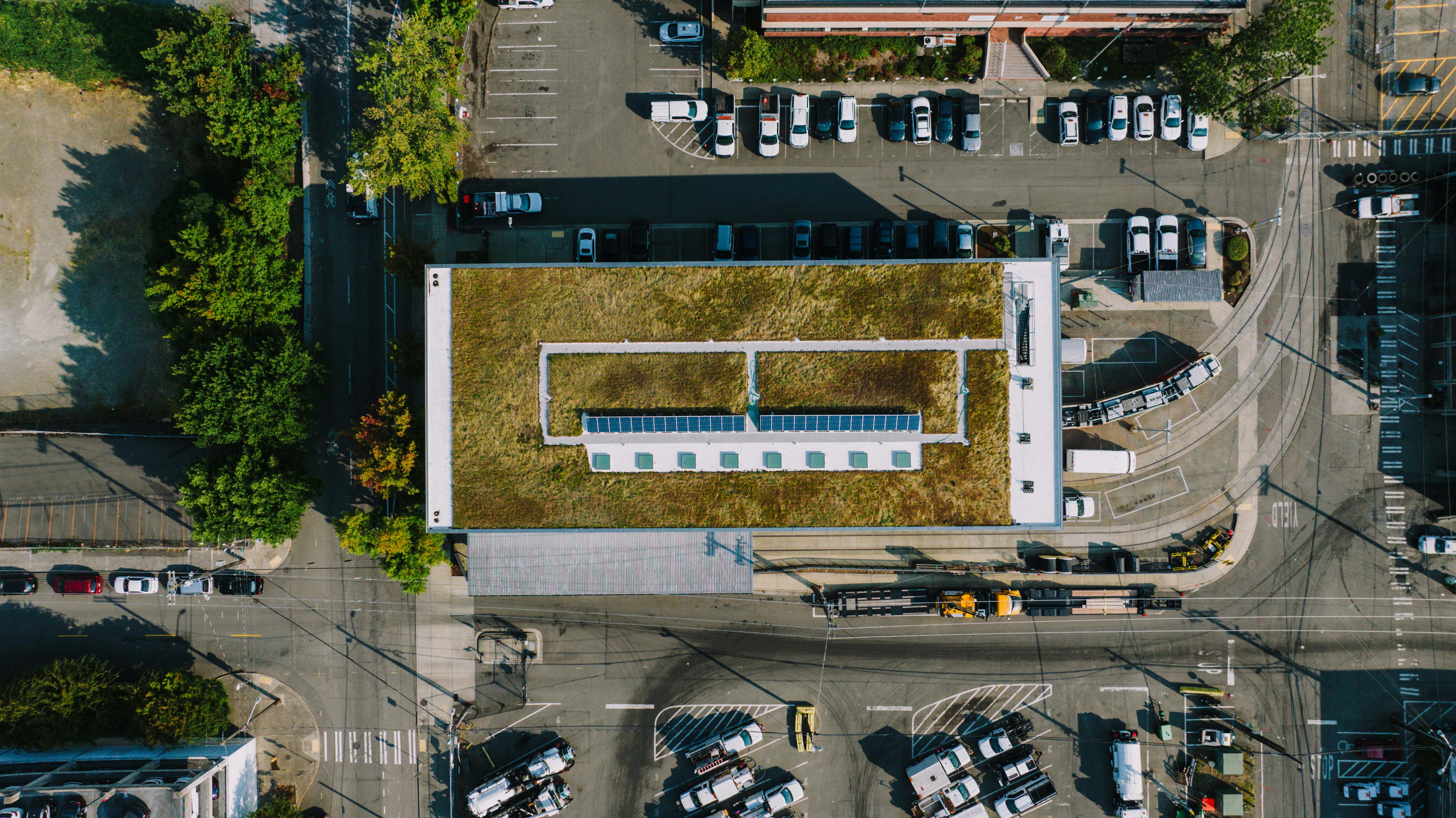 Aerial shot of a building with a green roof and solar panels in an urban Seattle setting.