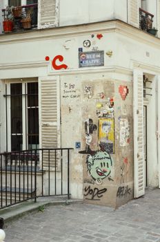 Graffiti and street art on a building corner in Rue Chappe, Paris. Urban culture snapshot.