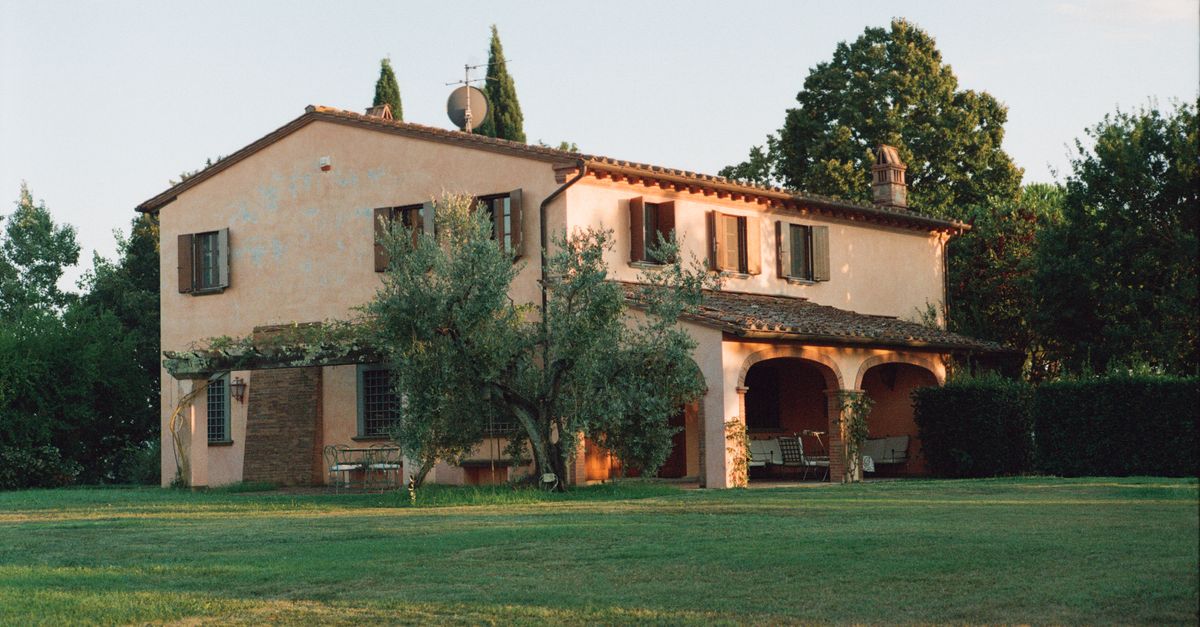 A charming rustic villa set in a peaceful Tuscan countryside, showcasing classic architecture and lush greenery.