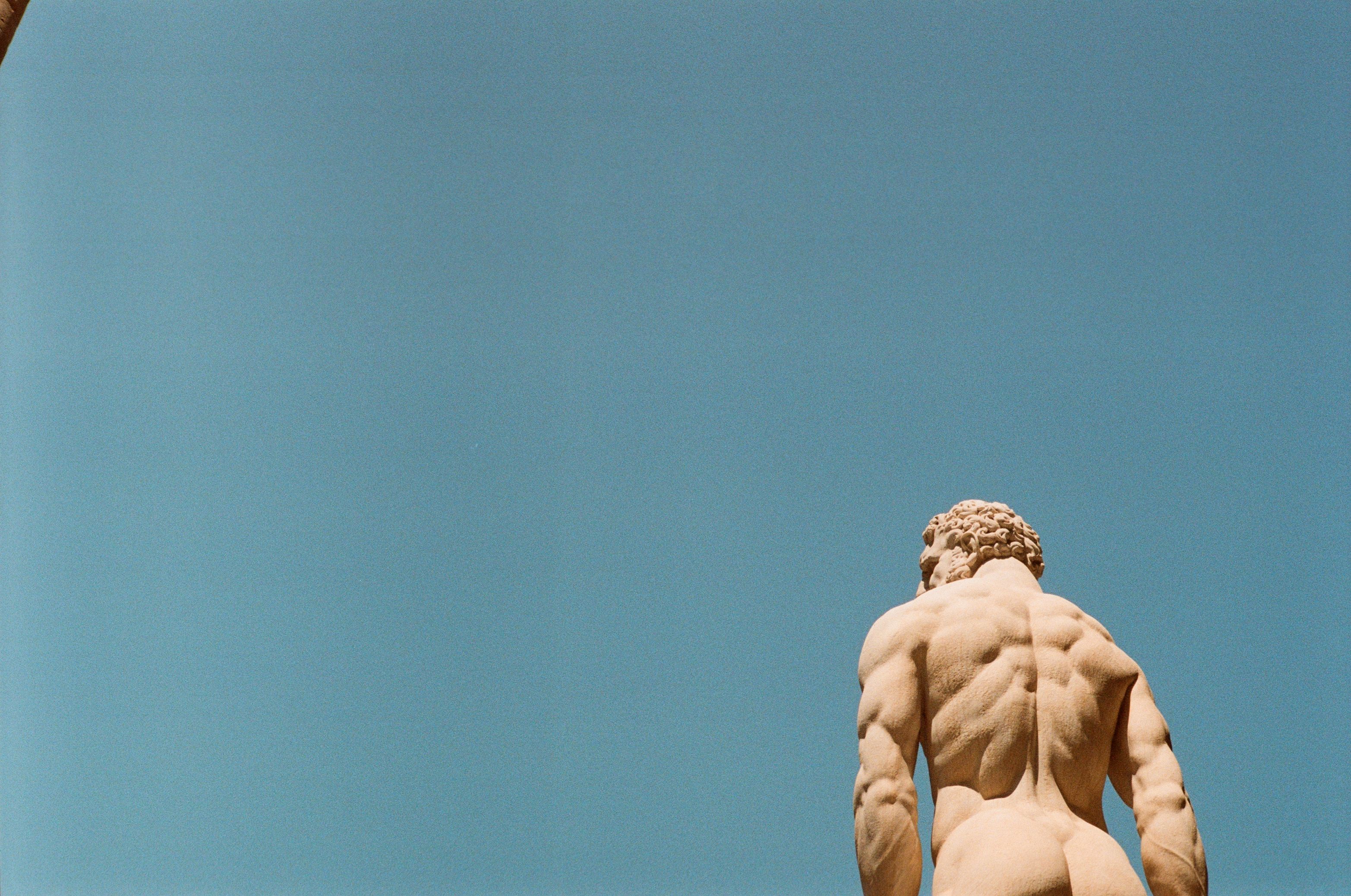 Back view of classical marble statue against blue sky · Free Stock Photo