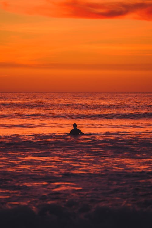 Person Swimming During Golden Hour