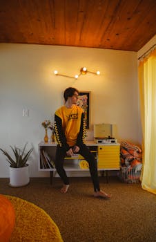 一位时尚男士穿着鲜艳的毛衣，坐在复古主题的客厅里，灯光温暖