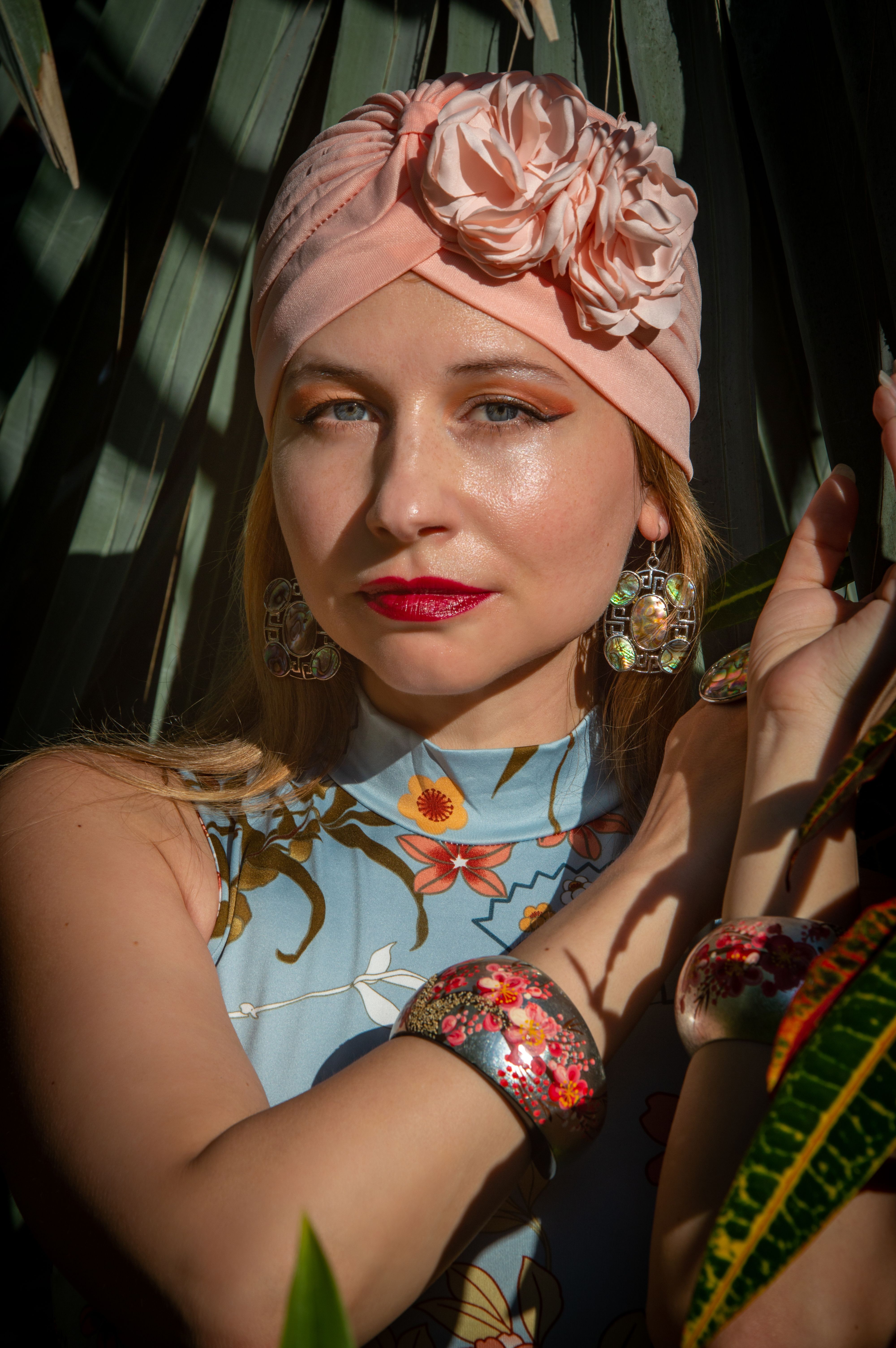 Elegant Woman in Floral Headscarf amidst Leaves · Free Stock Photo