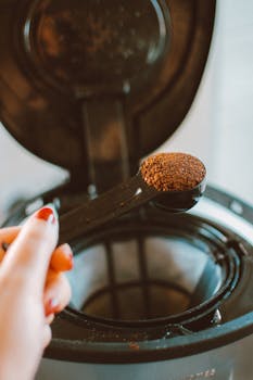 将研磨咖啡的特写镜头对准咖啡壶，准备冲泡新的一杯