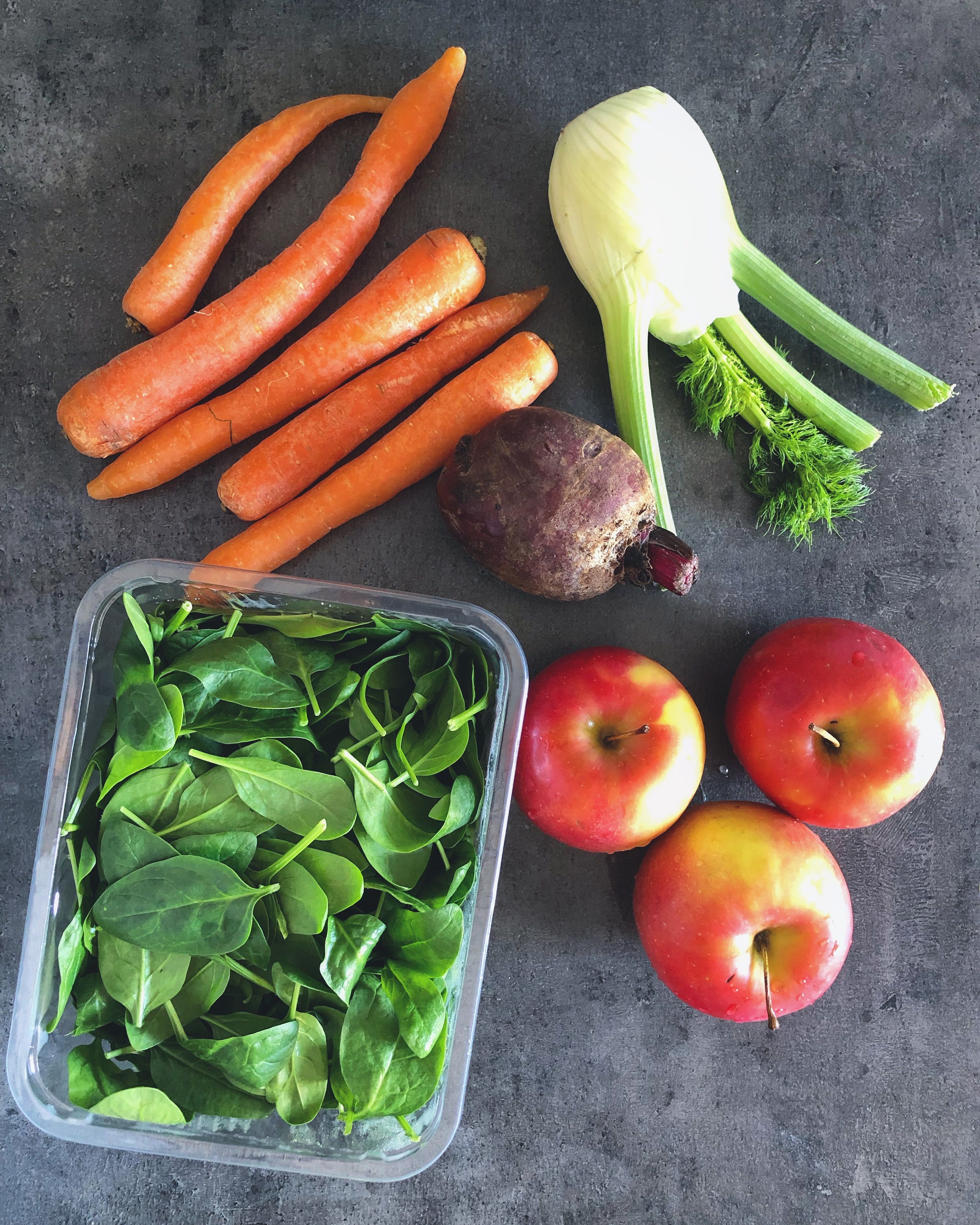 Assortment of healthy liver-friendly foods including greens, berries, and nuts