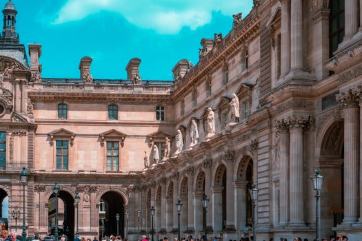 The stunning exterior of the Louvre Museum in Paris showcasing classic architecture under a clear sky.