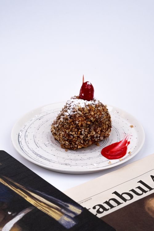 Free A gourmet dessert topped with cherry and nuts, served on an elegant plate. Stock Photo