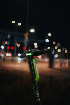 A street scene at night featuring an electric scooter amidst city lights and bokeh effects.