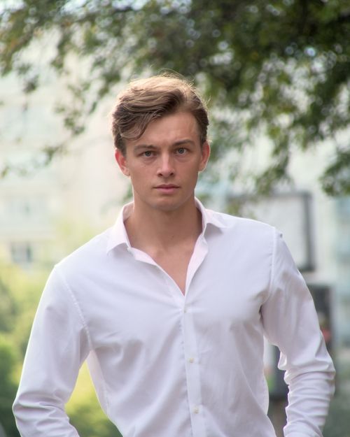 Free Young man posing outdoors in Berlin, Germany wearing a white shirt. Stock Photo