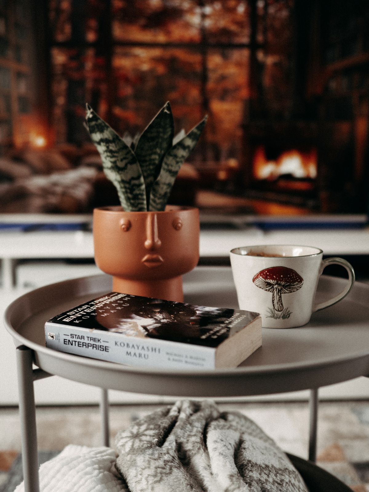 Coffee cup and book on a coffee table with cozy decor