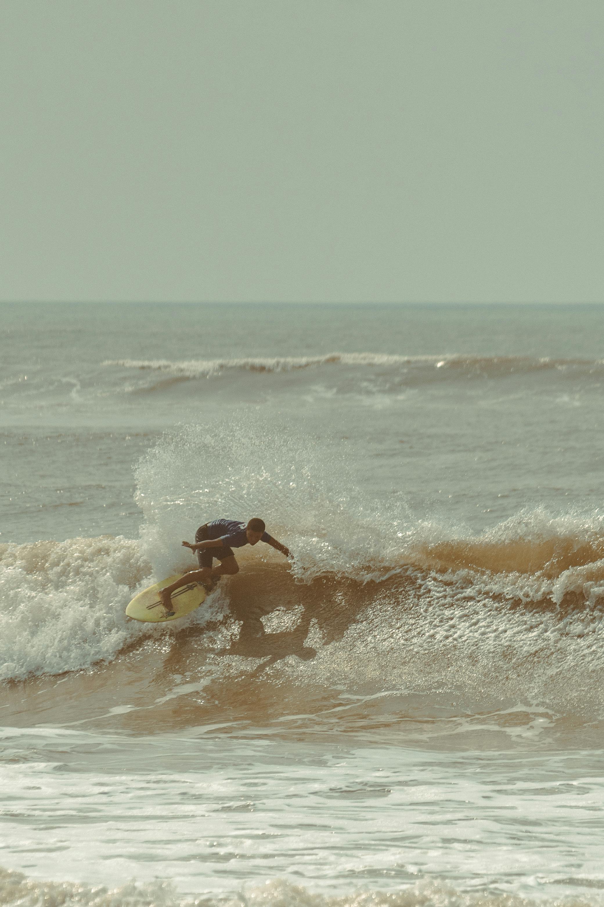 A surfer skillfully rides a wave, showcasing the thrill of ocean surfing in a vibrant setting.