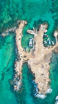 Stunning aerial shot of a rocky shoreline with turquoise waters in Protaras, Cyprus.