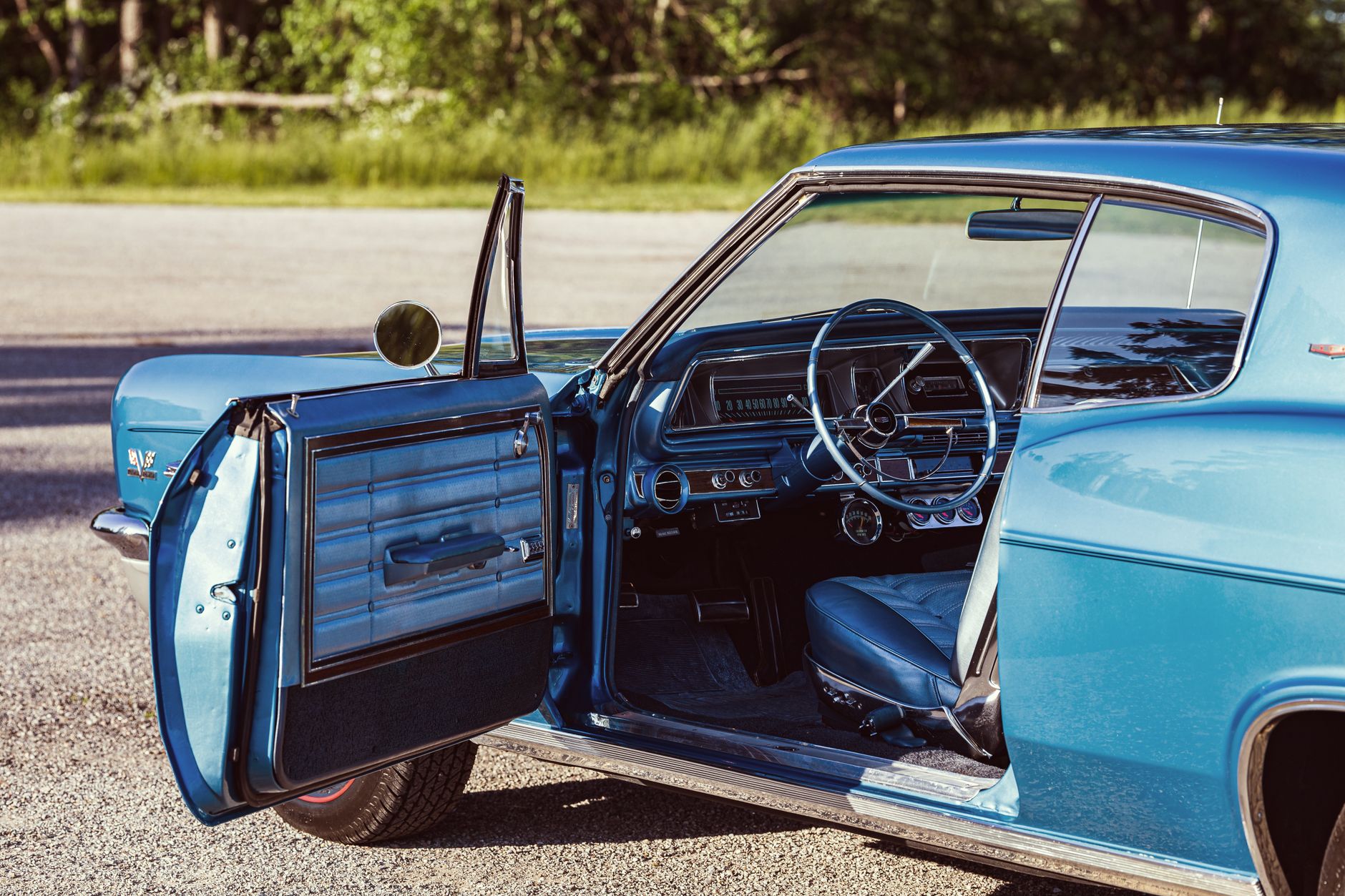 Open door view of a vintage 1966 blue Chevrolet Caprice, showcasing classic car interior and design.