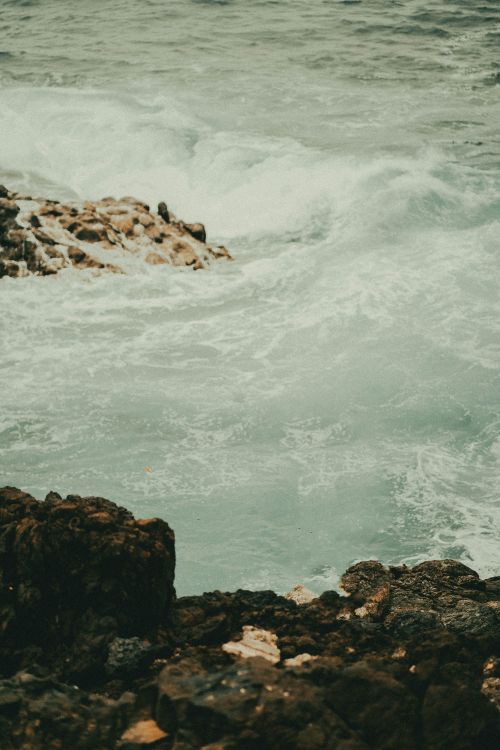 Free Waves crashing against a rocky coastline in Marmaris, illustrating nature's raw power. Stock Photo