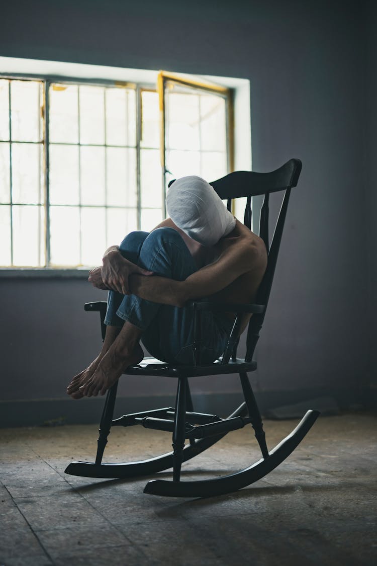 Person Sitting On Rocking Chair Inside Room