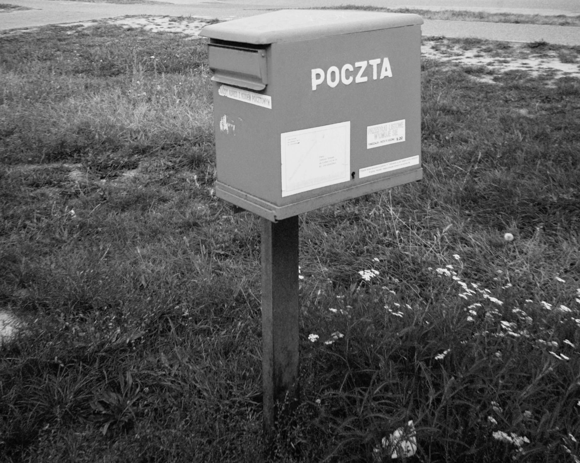 Black and white image of a Poczta mailbox in Warsaw, Poland.