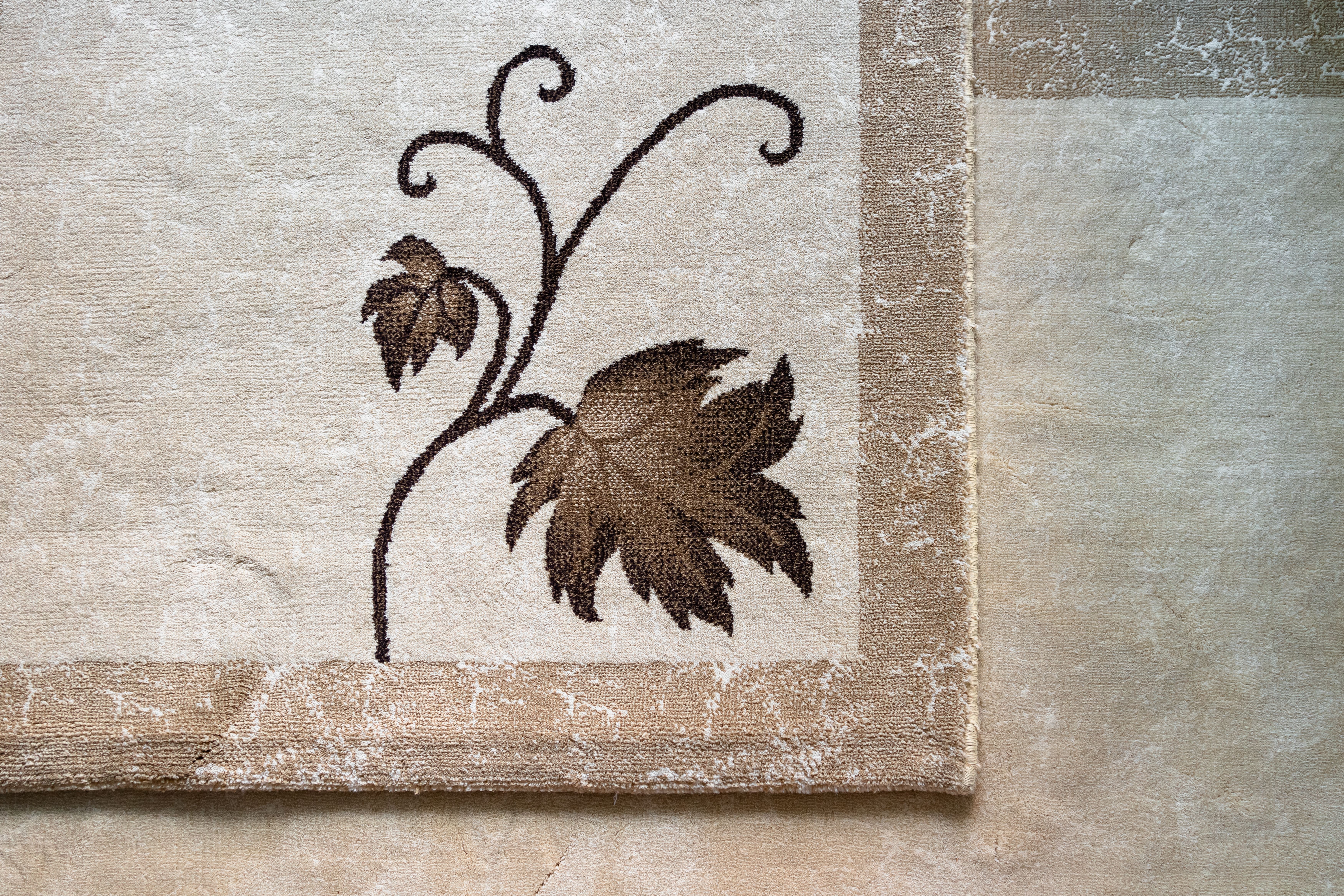 Close-up of an intricate leaf pattern on a textured beige fabric background, showcasing artistic design.