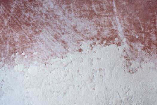Close-up abstract texture of a pink and white surface resembling plaster or paint.