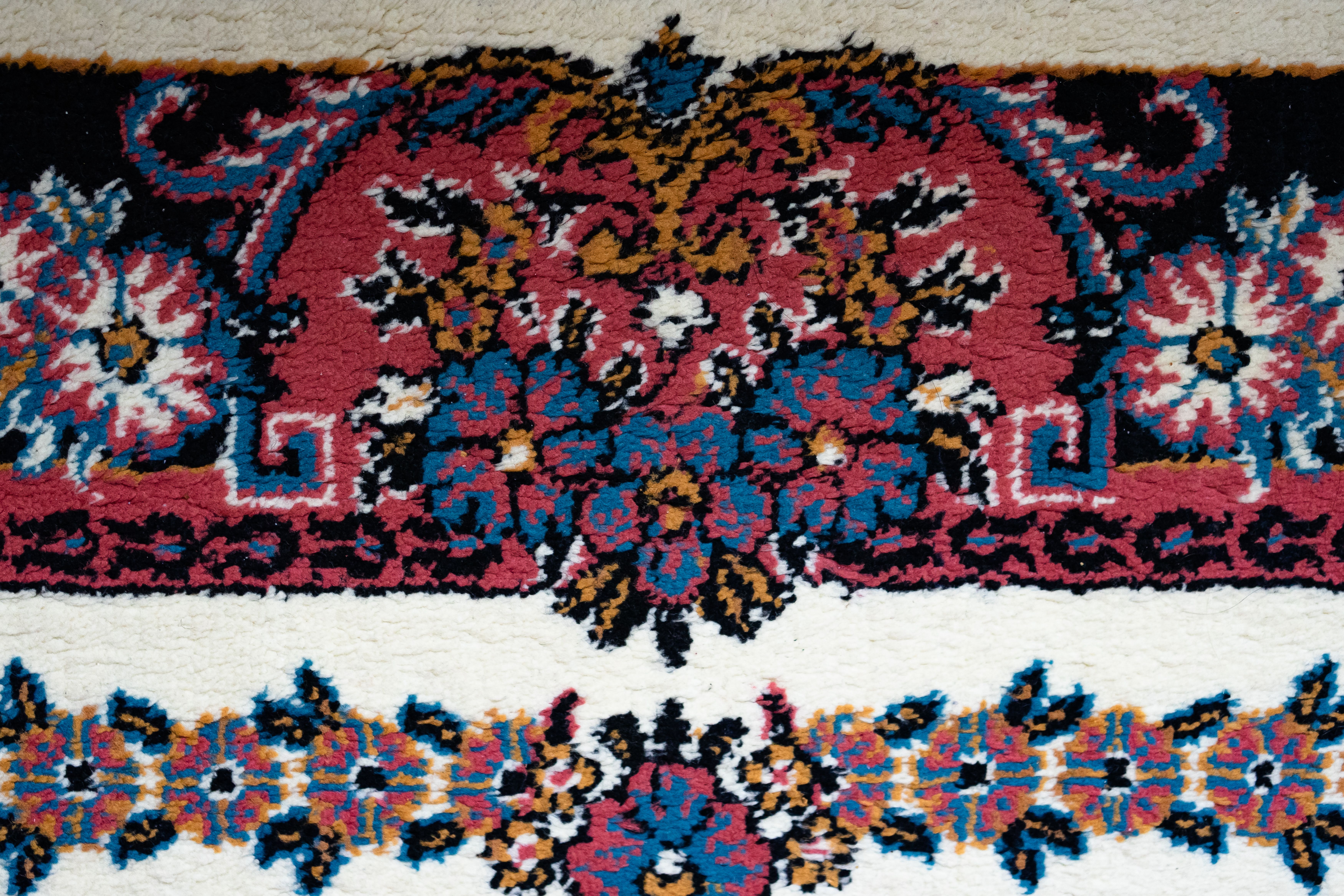 Close-up of a colorful traditional floral carpet with intricate patterns.
