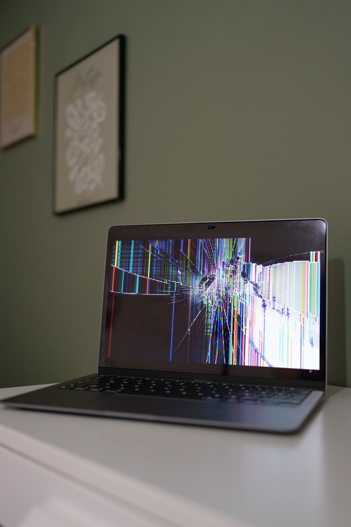 Laptop with a cracked malfunctioning screen representing a defective consumer product