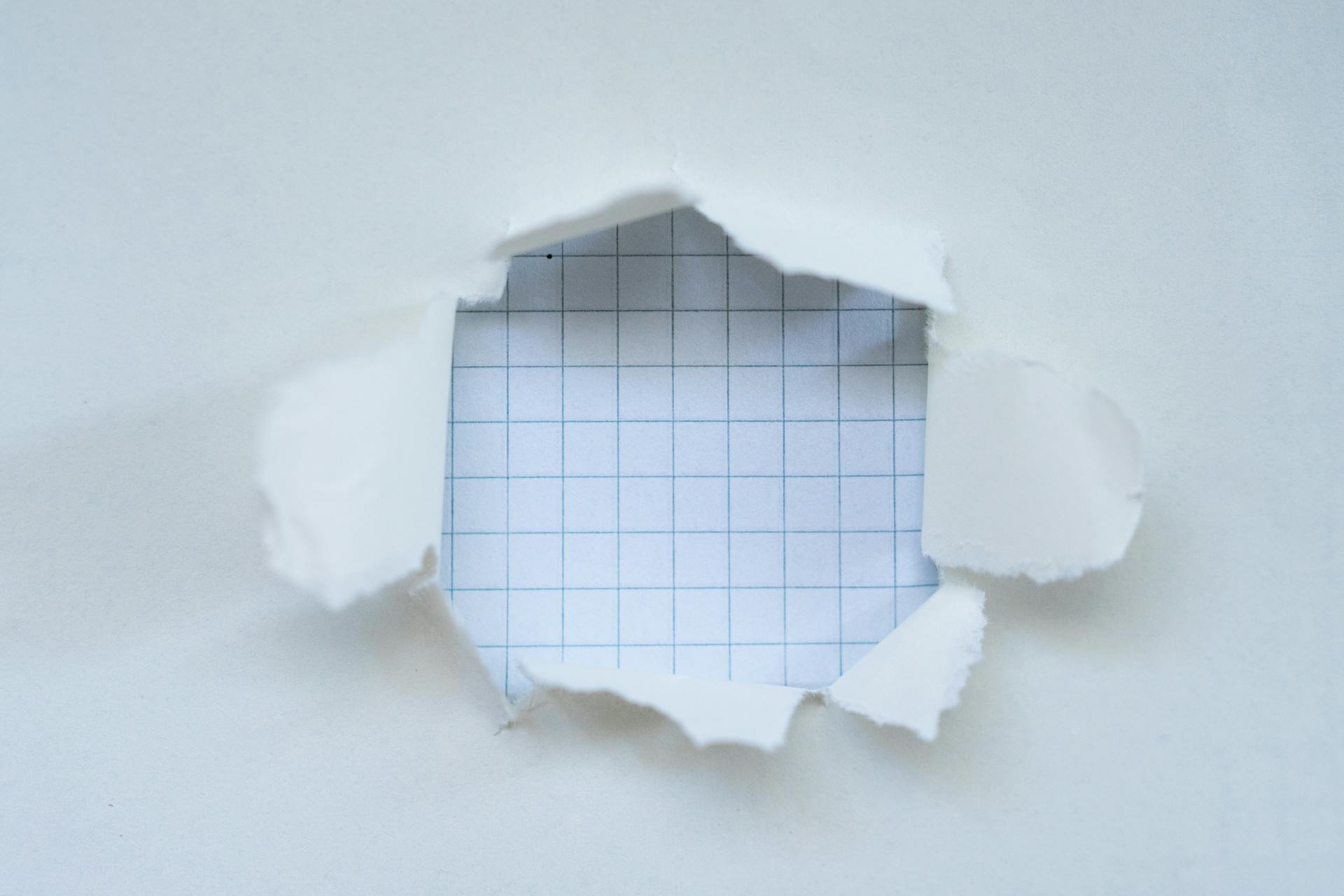 A hole in a sheet of paper with a grid