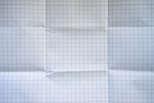 Close-up of a wrinkled grid paper texture with folded creases.