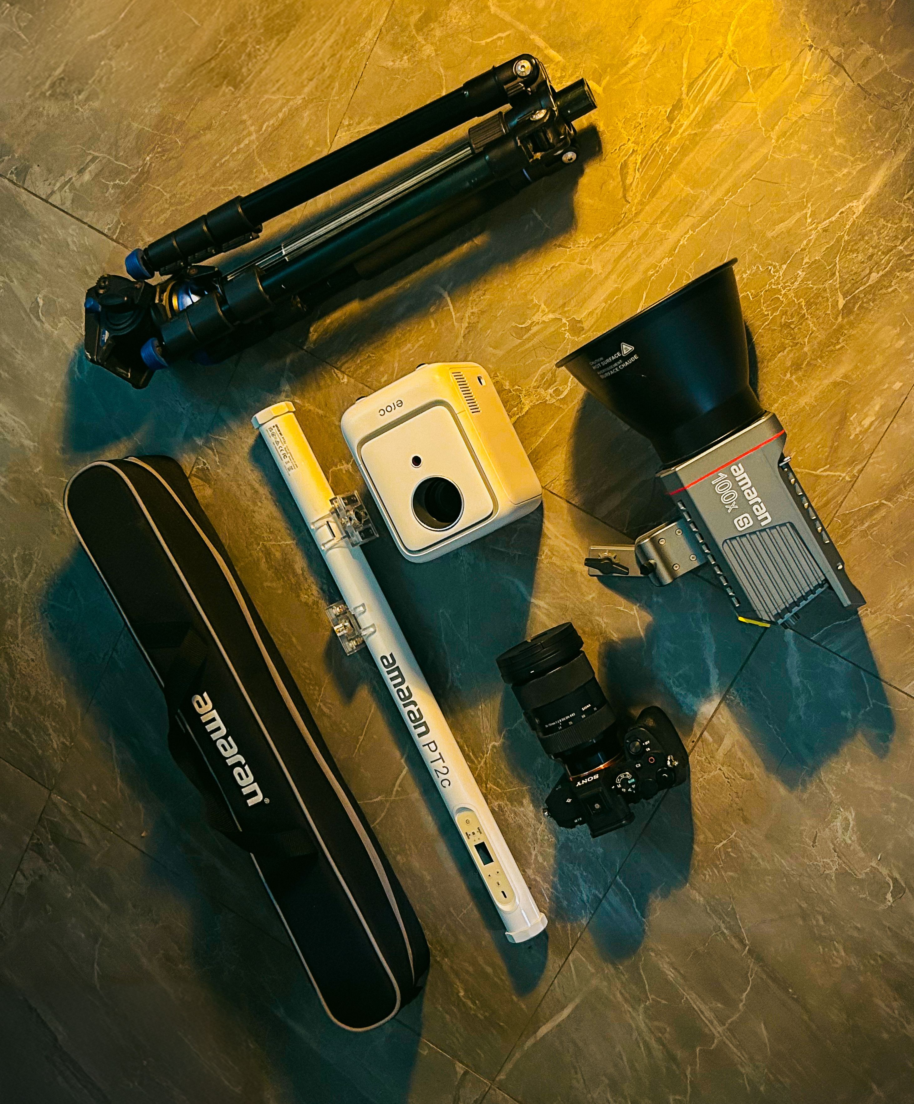 Flat lay of essential photography gear including cameras, tripods, and lighting equipment for professional setups.