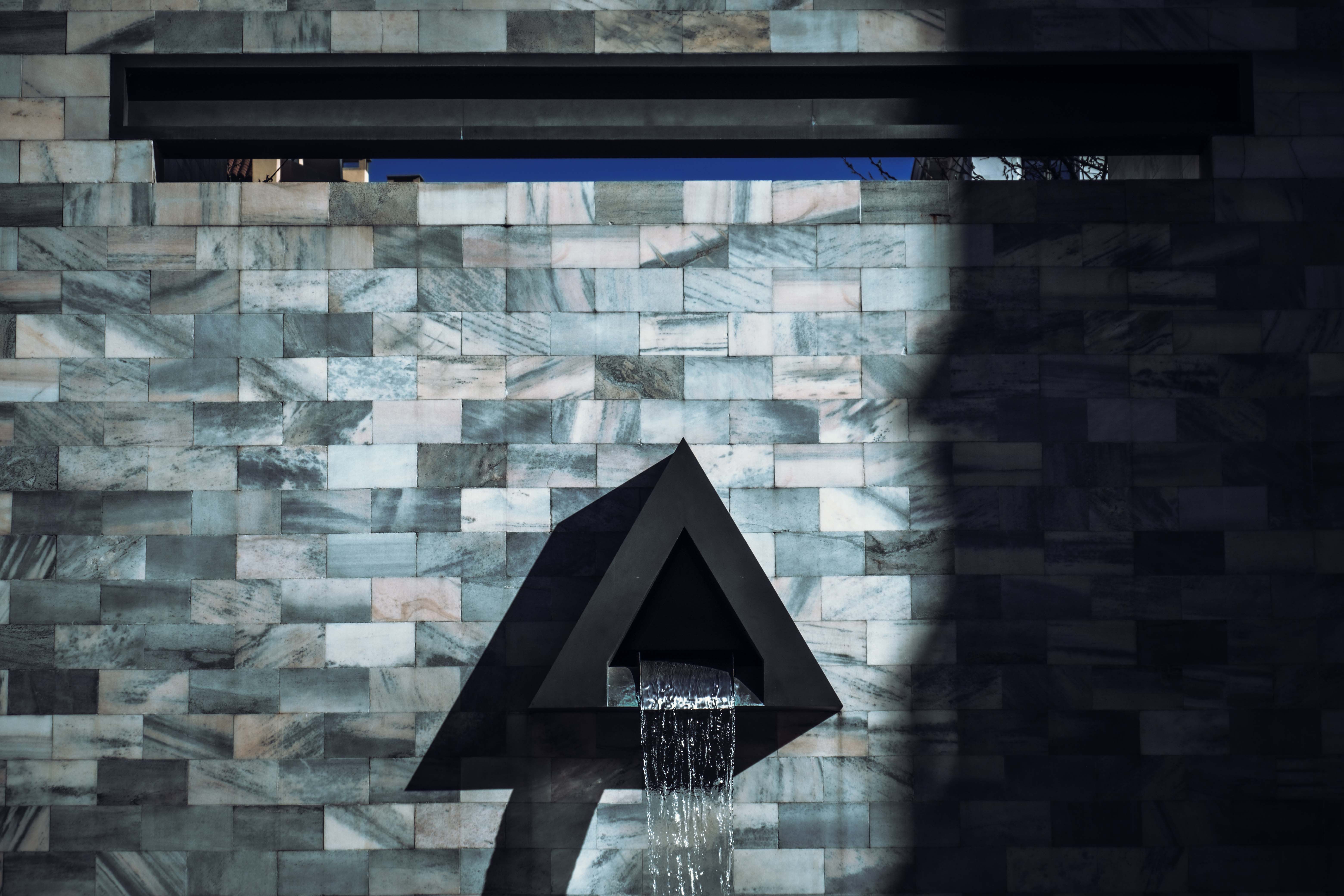 A black triangle is on the wall next to a shower · Free Stock Photo