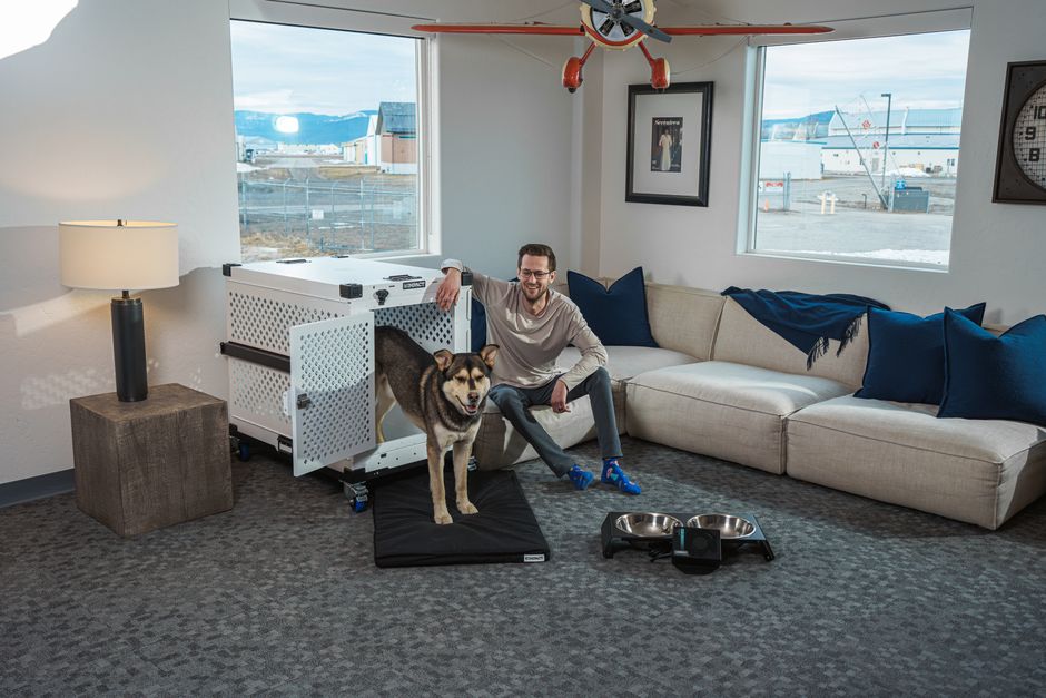 How Crate Training Solves Puppy Housebreaking and Separation Anxiety Man with a dog in a modern living room setting, emphasizing pet safety and comfort.