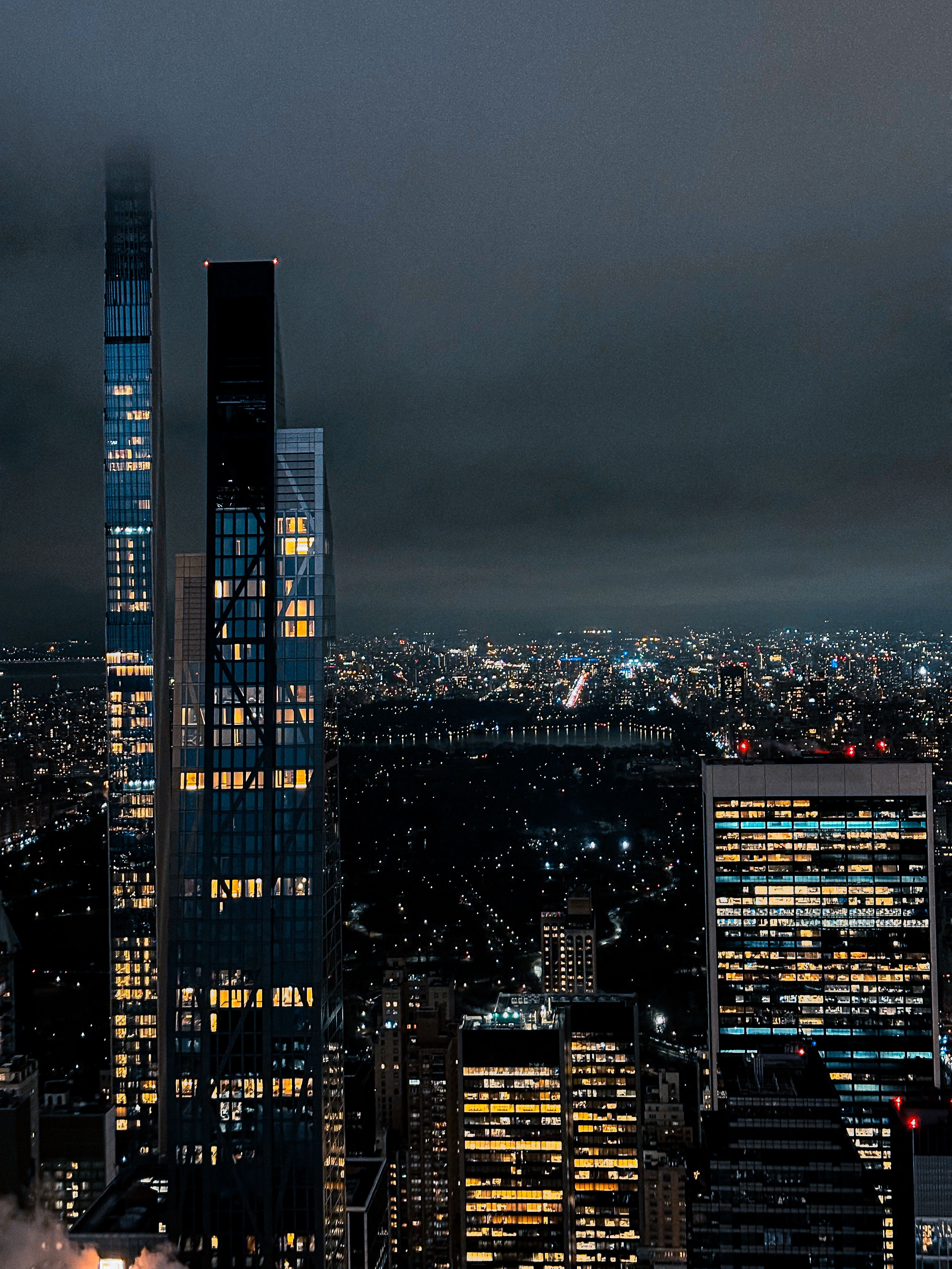 A city skyline at night with buildings lit up · Free Stock Photo