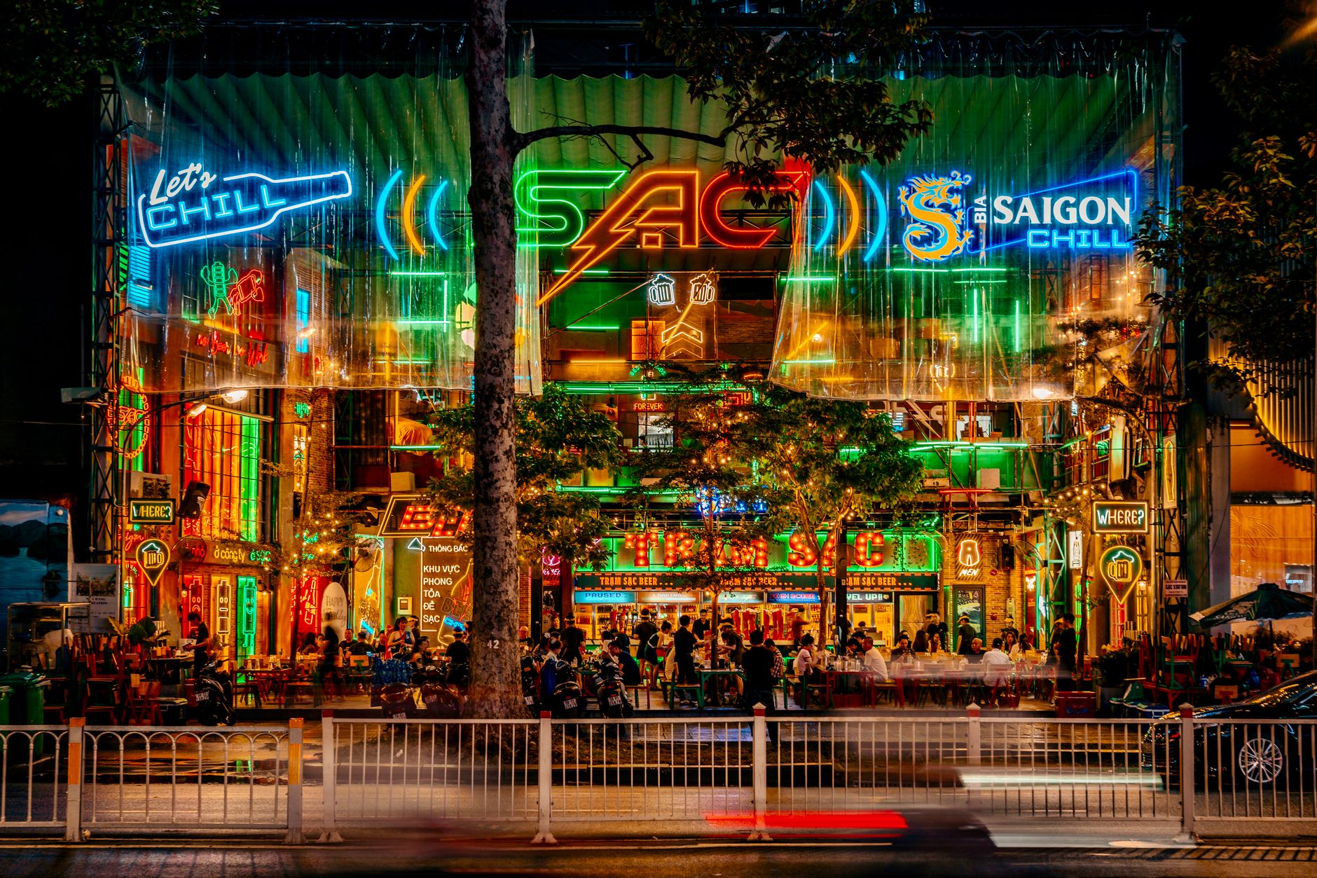 Neon-lit Saigon street scene bustling with activity at night.