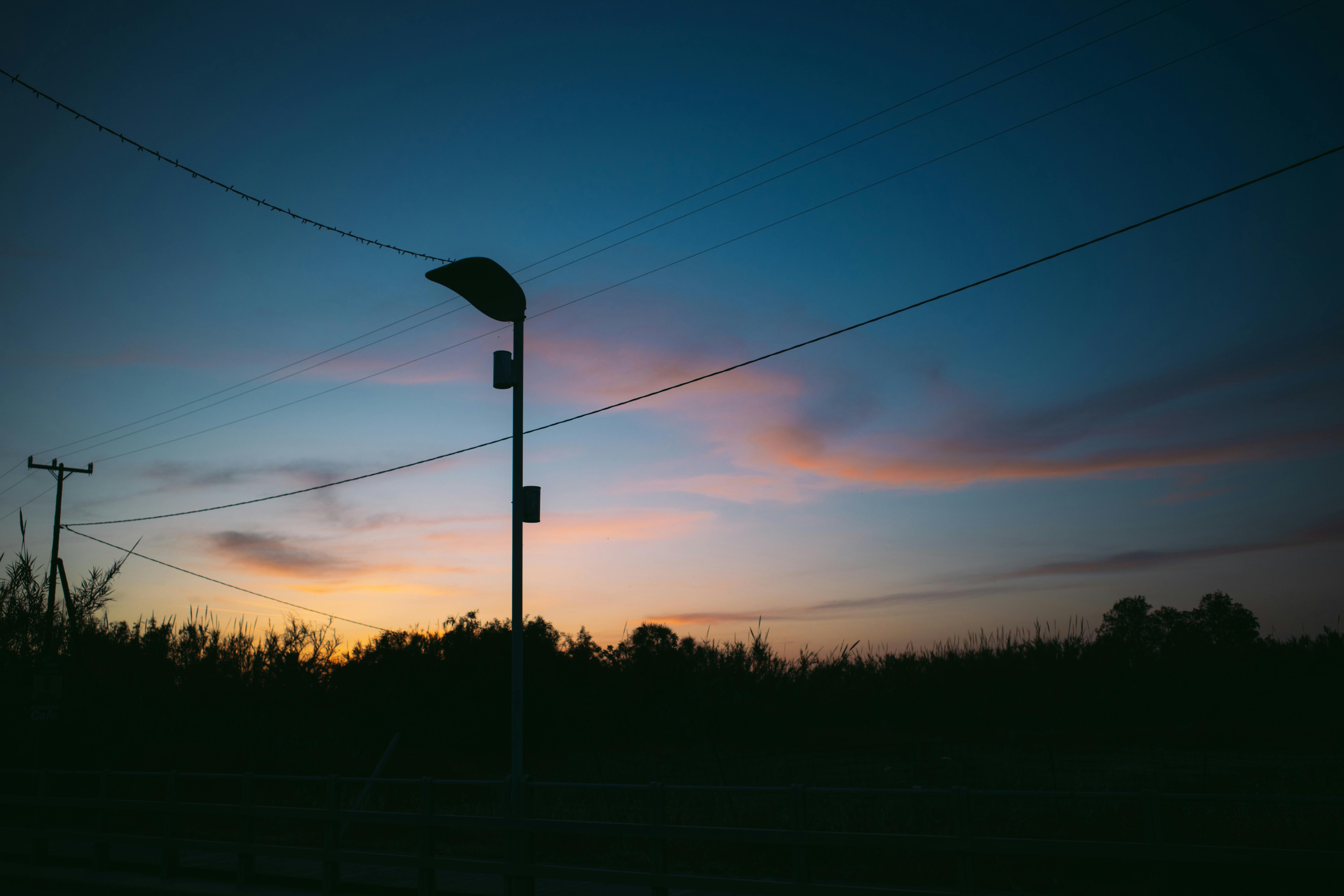 Vibrant sunset in Rethymno, Greece, showcasing silhouettes of lampposts and power lines.