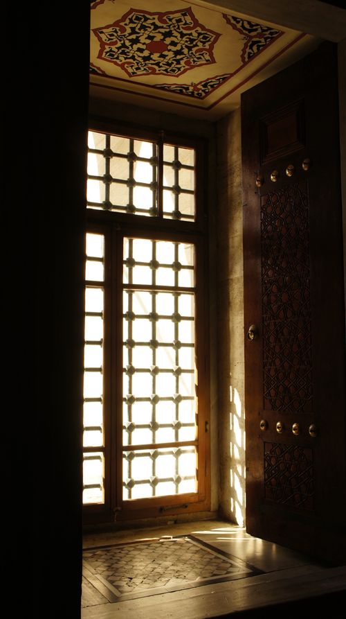 Free Sunlight streams through a beautifully designed traditional window, casting intricate shadows. Stock Photo