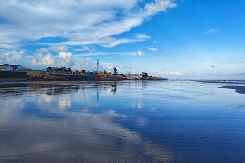 Free Peaceful beach with vibrant sky reflections in Mandarmani, India. Stock Photo