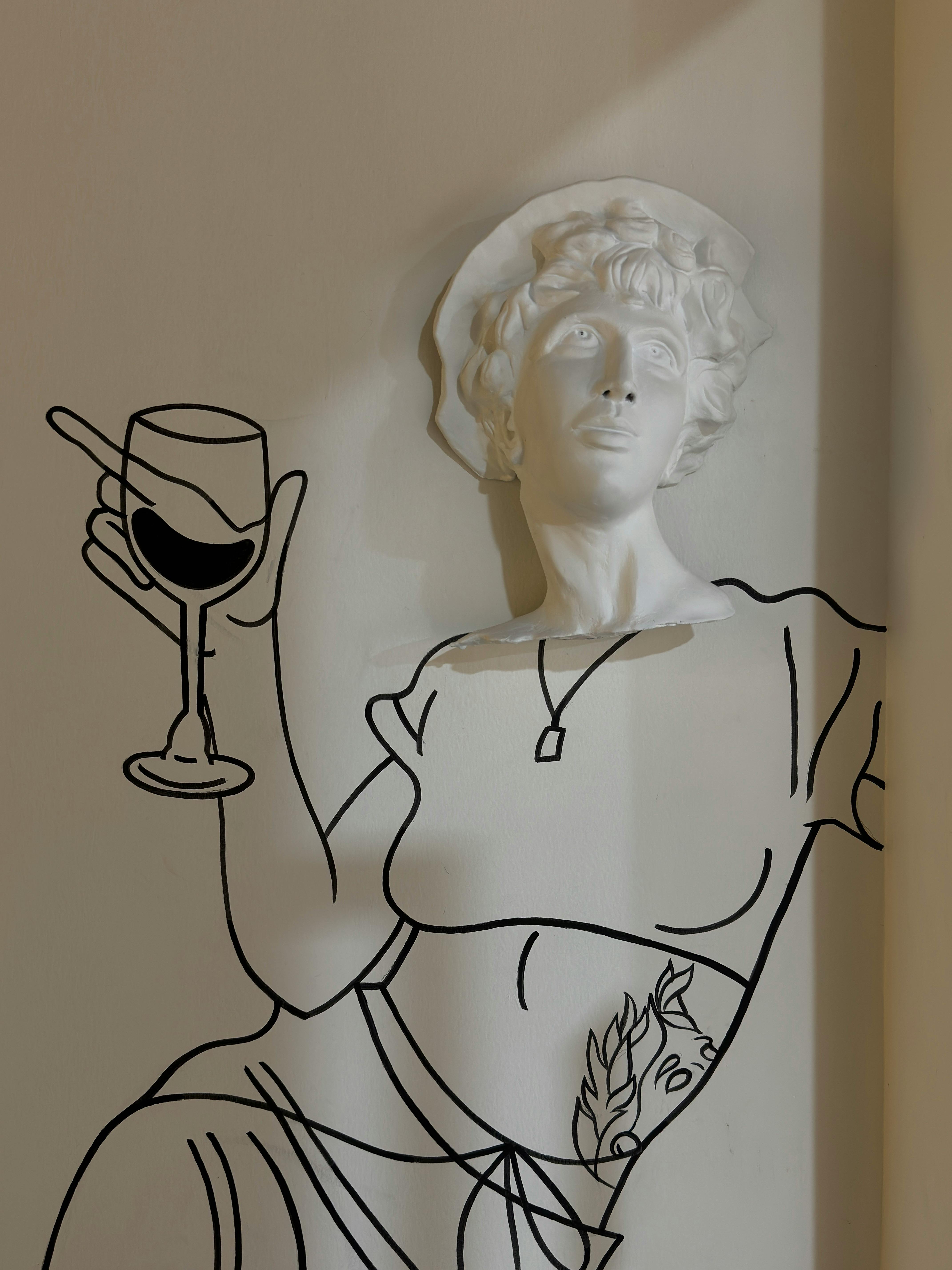 a sculpture of a woman holding a wine glass