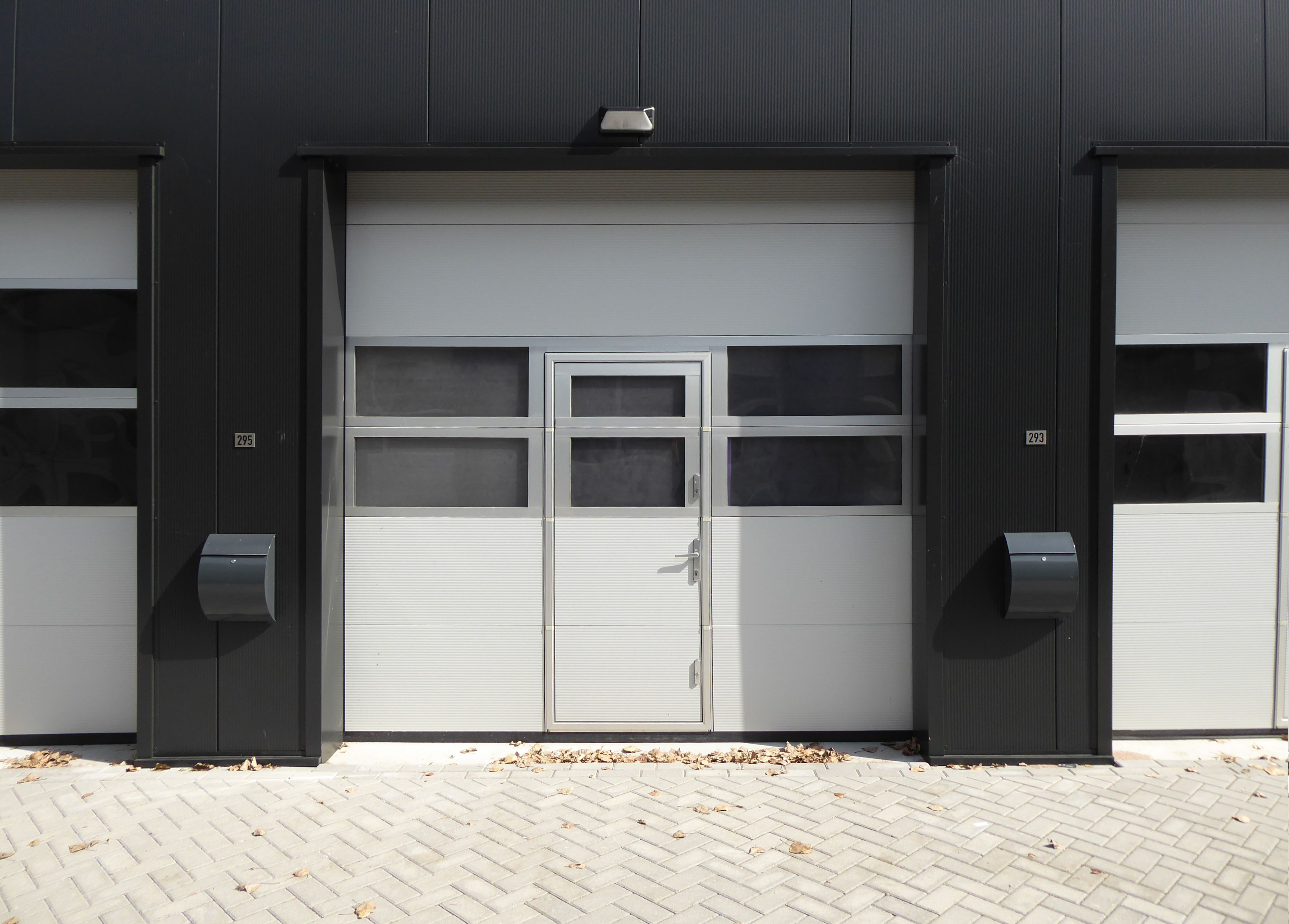 Modern industrial sectional door with entrance suited to commercial garage door installation in Fargo