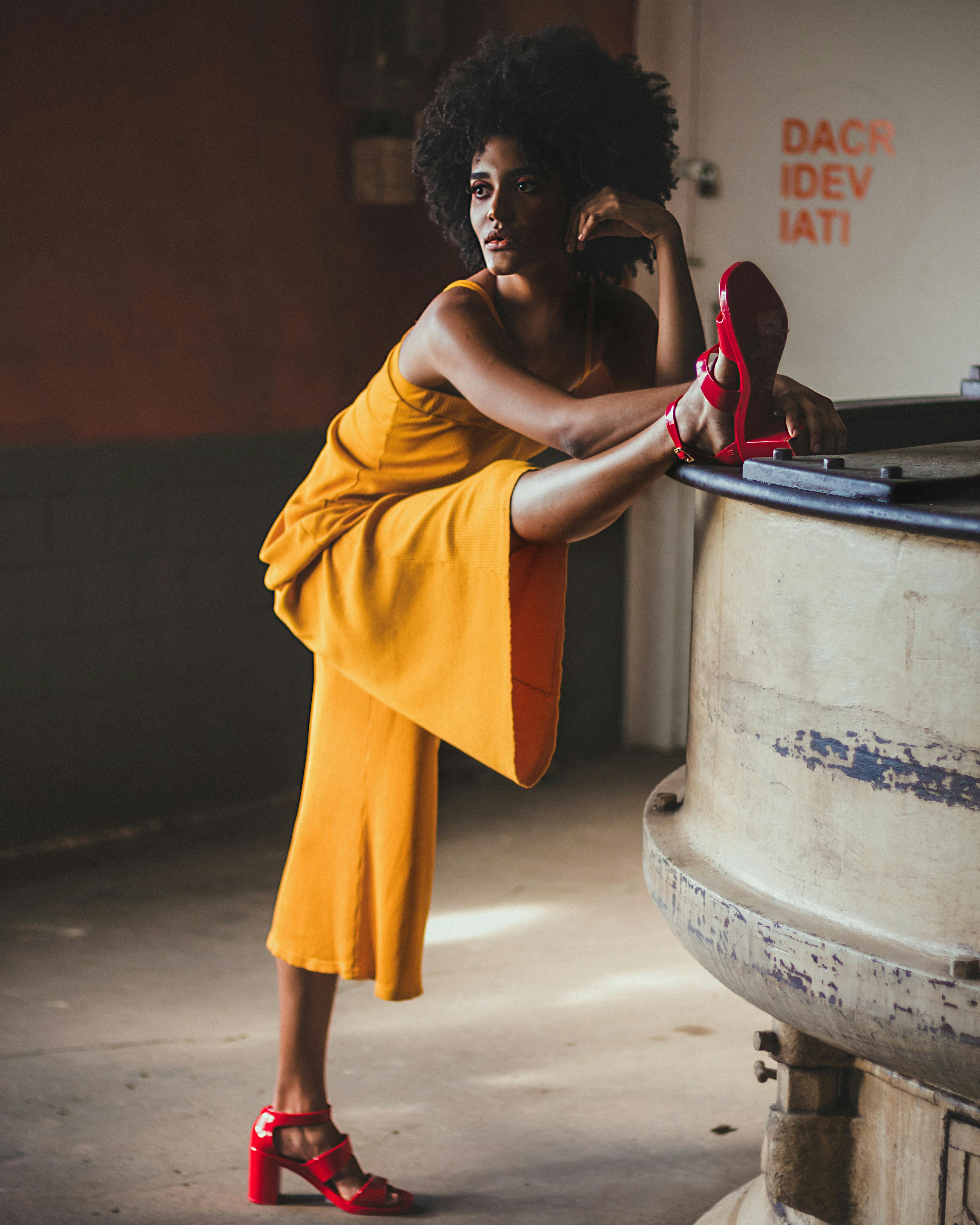 Gratis Wanita Bercelana Kuning Mengenakan Kaki Kanan Di Mesin Abu Abu Foto Stok