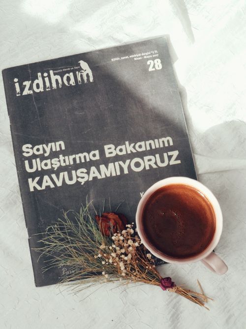 Free Cup of coffee next to a magazine and dried flowers on a white background Stock Photo