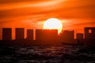 充满活力的日落反映在与剪影的建筑和船的水