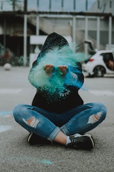 一个人坐在街头，用充满活力的绿色粉末创作，将时尚与城市艺术融为一体