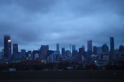 Free A moody cityscape of Chicago featuring high-rise buildings at twilight under a cloudy sky. Stock Photo